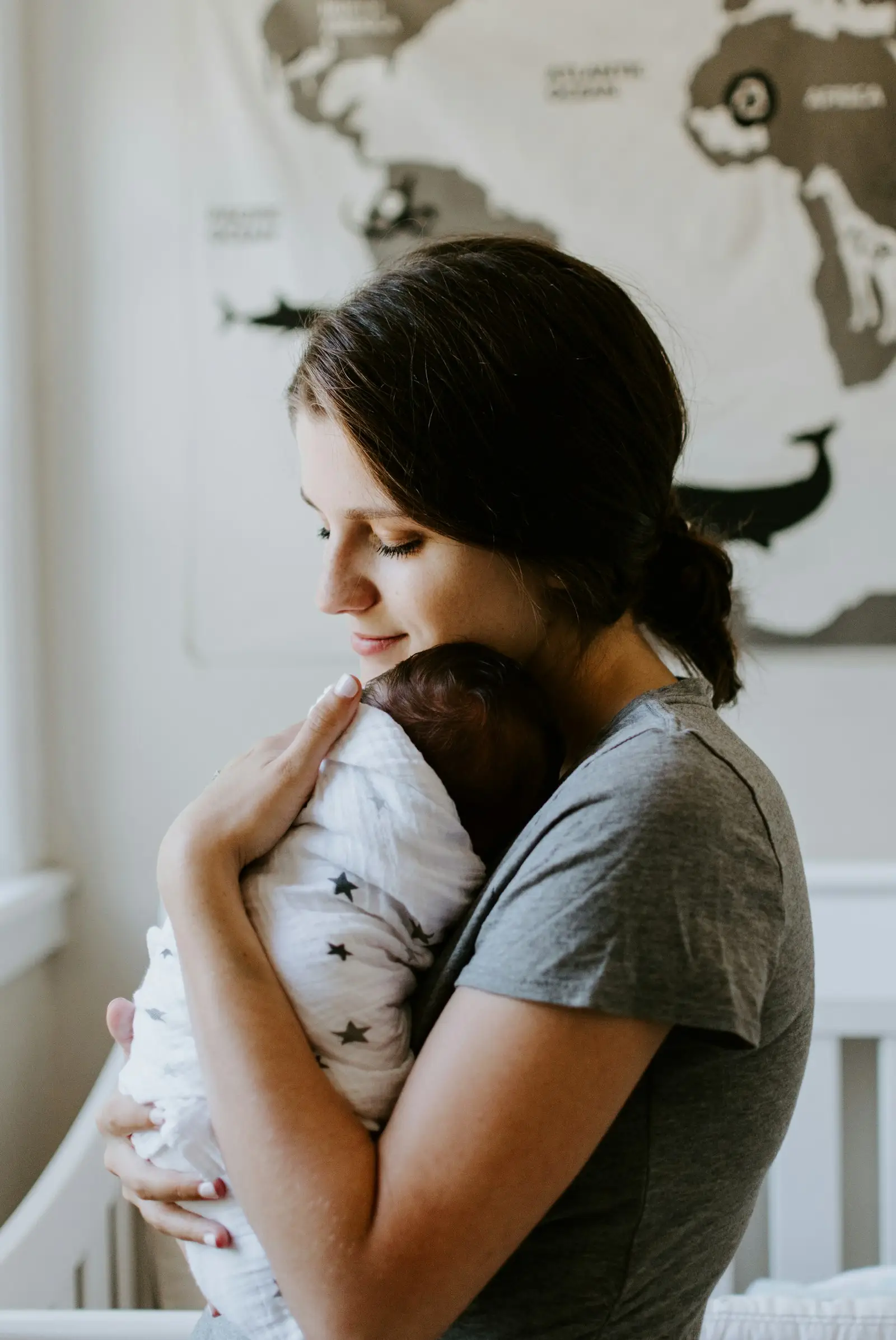 A mother holding her baby close against her shoulder