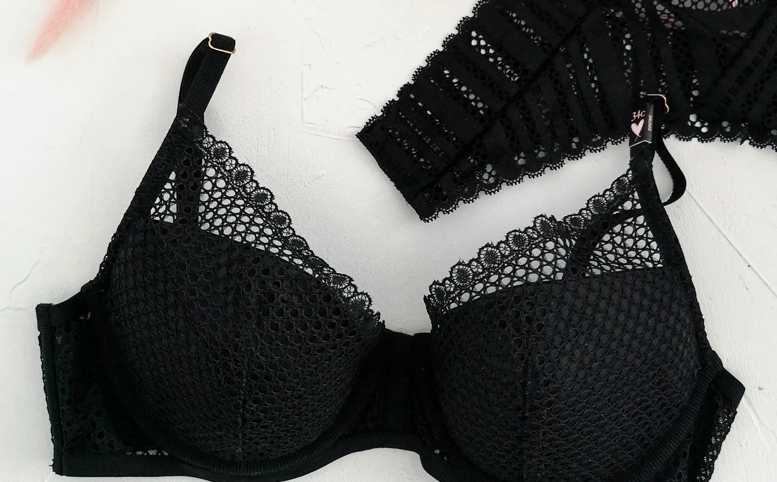 A black padded underwired bra with lace edging laid flat on a white surface