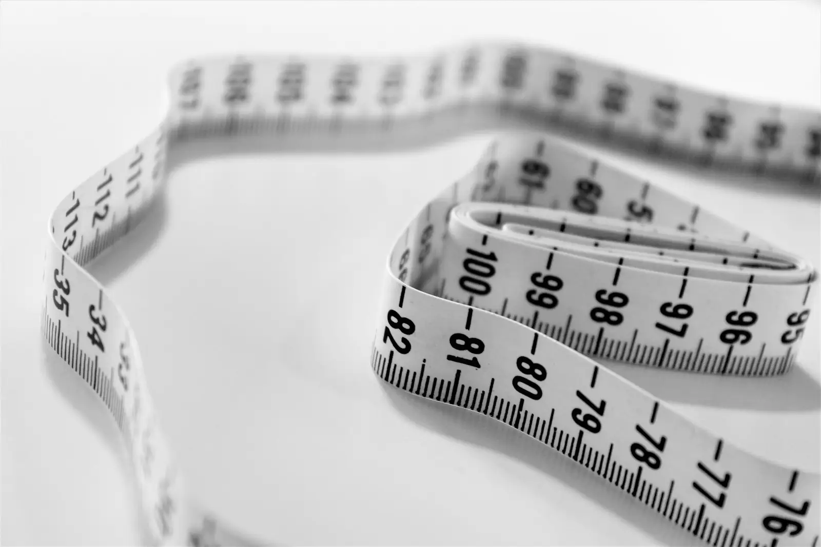 Close-up of a white measuring tape with inch and centimeter markings